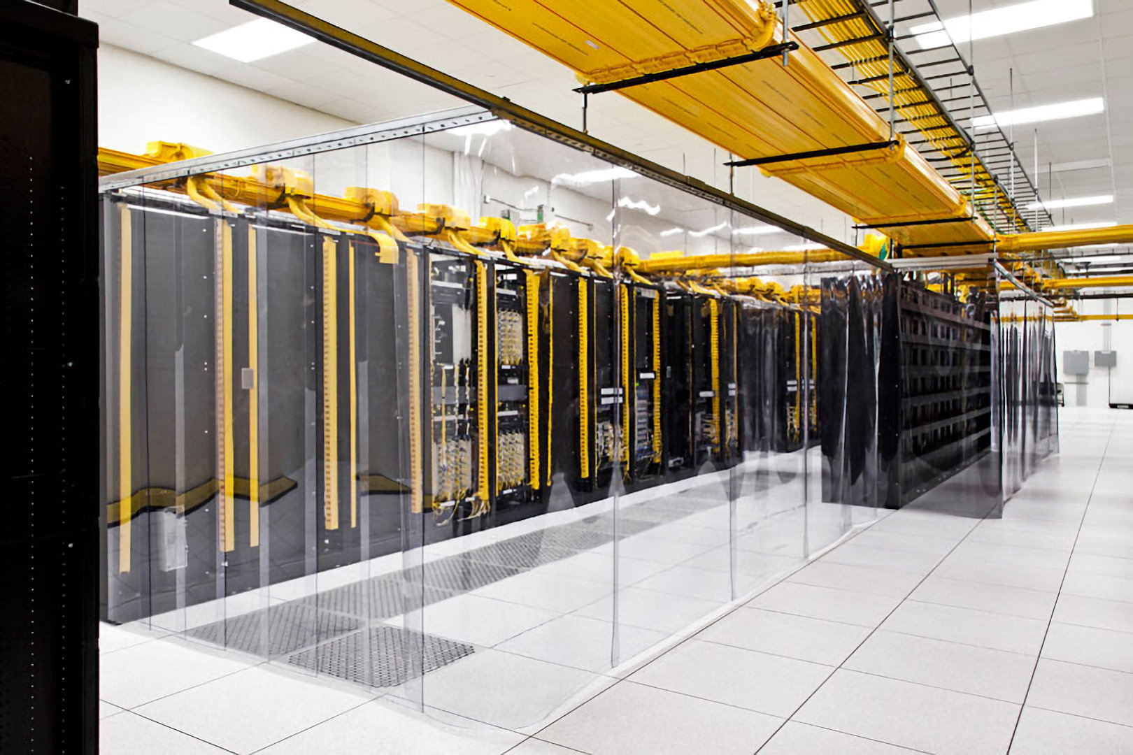 yellow structured fibre cabling to racks in large data centre