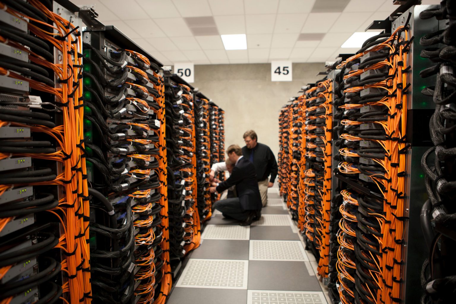 engineers working on structured data cables within data centre