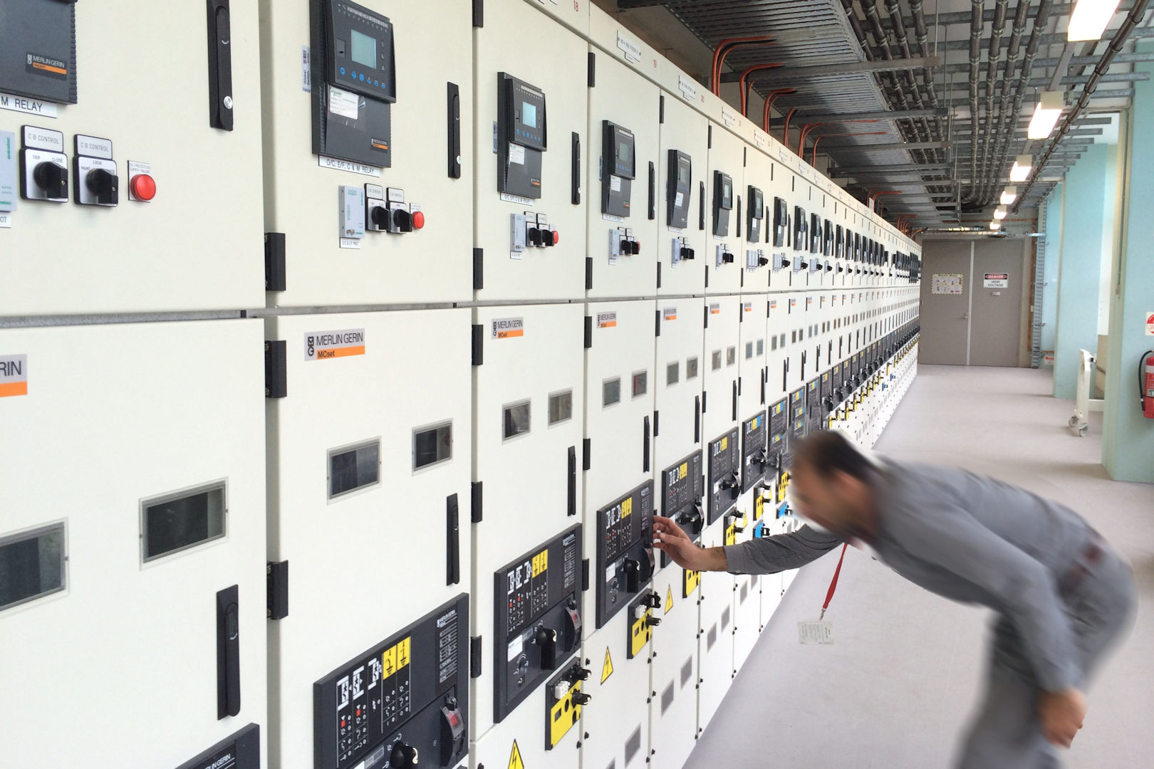 electrician switching circuit breaker on large main switchboard